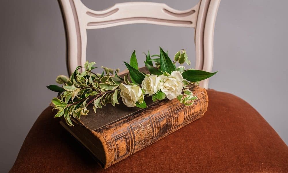 A large poetry book with a white poesy on it, placed on a wooden chair.