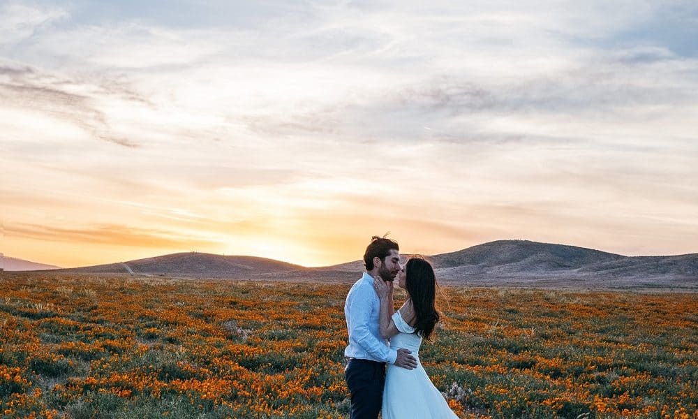 Newly weds dancing in a field.