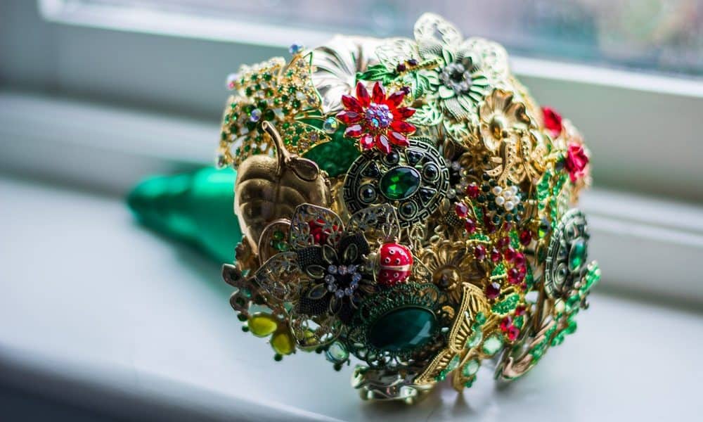 Jewelled brooch bouquet made of golds, reds, and greens.
