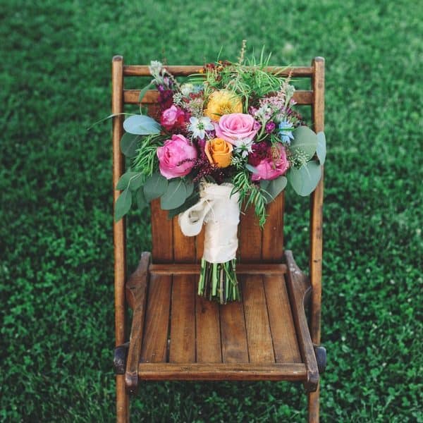 Wooden chair with colorful floral bouquet.