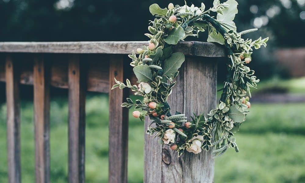 Rustic wreath hanging on a wooden bench.