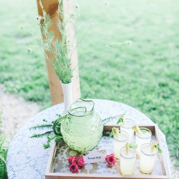 Jug of lemonade, glasses and pink flowers