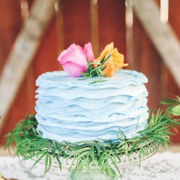 Turquoise wedding cake with bright colored roses.
